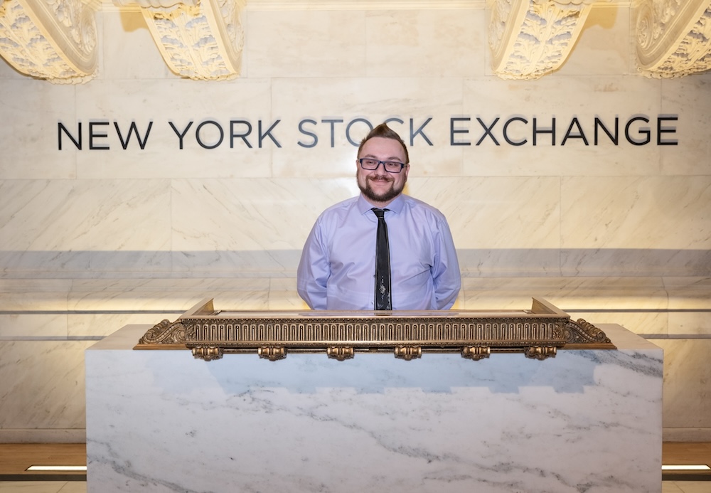 Man standing in front of NYSE sign